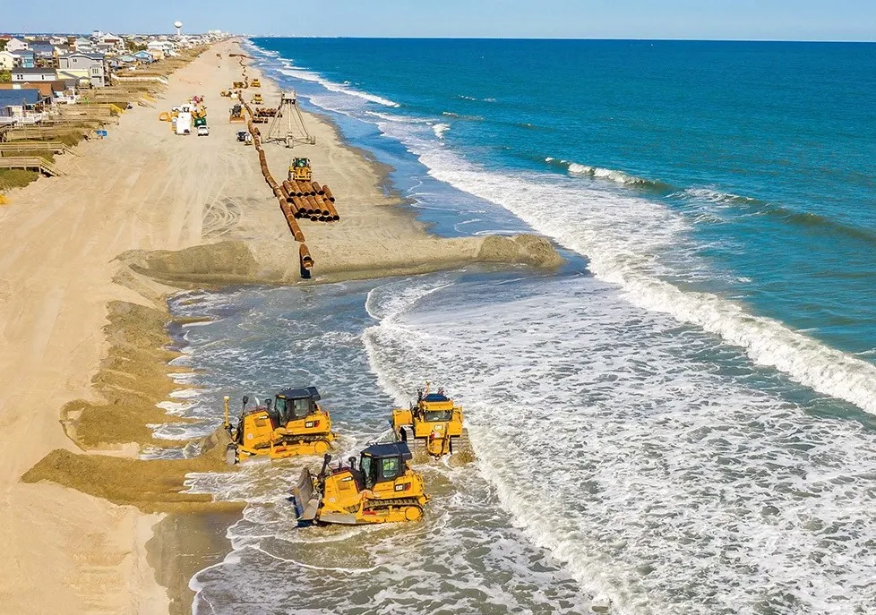 A photo of the beach replenishment process taking place on another beach, giving readers some idea of how much beach would be restored.