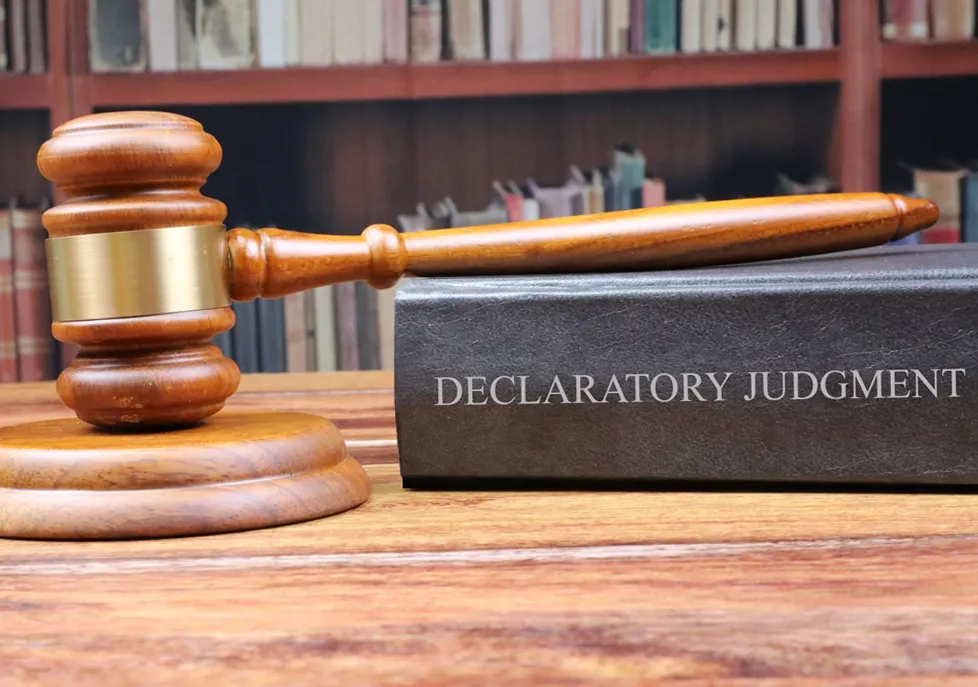 A photo of a judges Gavel on top of a Declaratory judgement legal book, which is what is needed to go ahead with the beach replenishment.